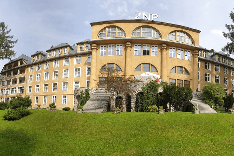 Żółty budynek Ośrodka ZNP NCWR w Zakopanem na tle Tatr